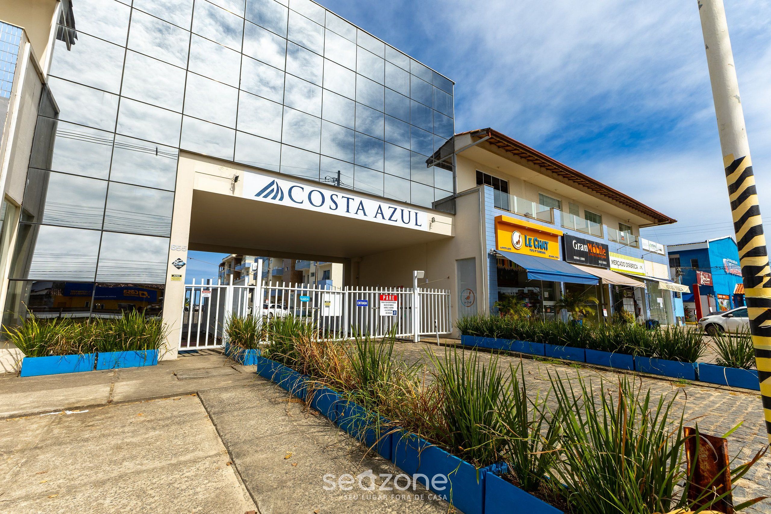Un bâtiment moderne avec une façade en verre et une enseigne indiquant « COSTA AZUL ».