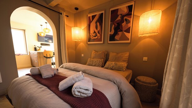 Une chambre à coucher avec un grand lit, deux lampes de chevet et des œuvres d’art accrochées au mur.