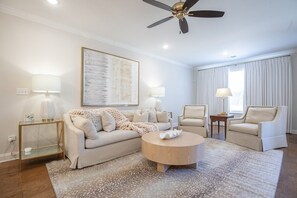 A modern living room with a sofa, two armchairs, a coffee table, a floor lamp, and a ceiling fan. - The Alexa, 3BR Retreat by Velvet Ditch Villas (Oxford)