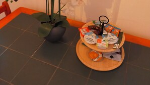 Una taula de menjador amb un vas de orquídies blanques i un plat de diferents aperitius.