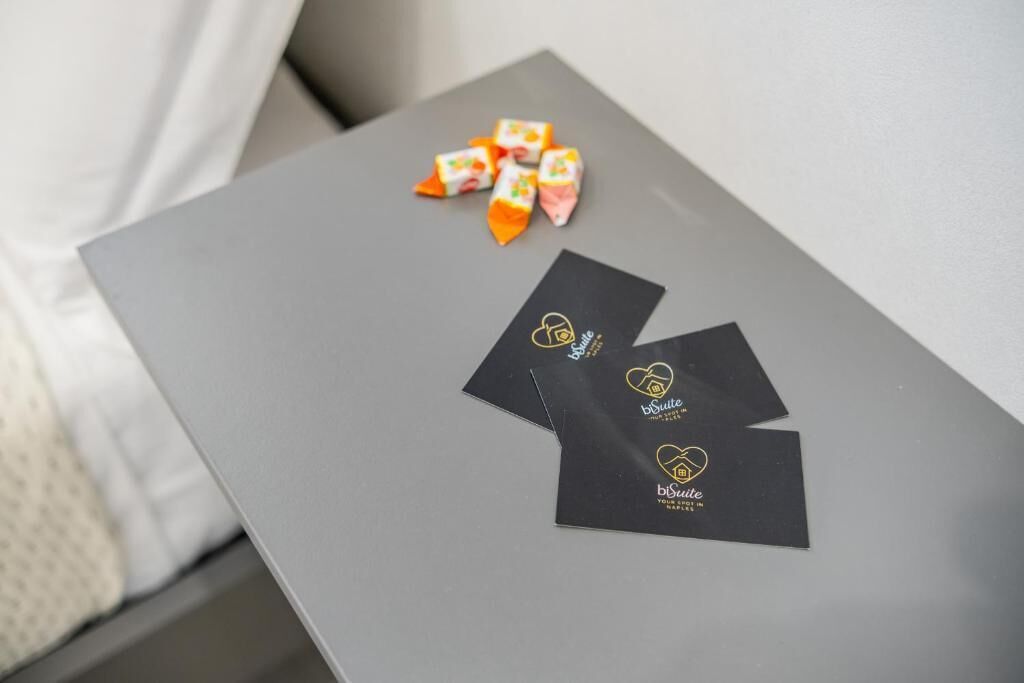 A grey table with three black cards and some colorful wrapped items on it.