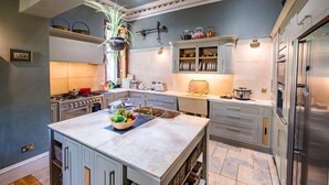 A modern kitchen with a central island, built-in appliances, and a variety of storage cabinets. - Argyll Country House (Clachan)