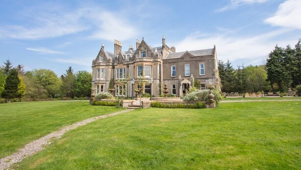 A large, historic building with a symmetrical facade, multiple chimneys, and a well-maintained lawn in front. - Argyll Country House (Clachan)