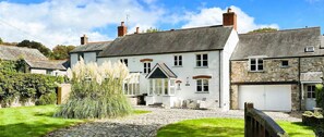 A two-story house with a stone facade, a white exterior, and a grey roof. - Sea Mist House - Six Bedroom Villa, Sleeps 14 (Charlestown)