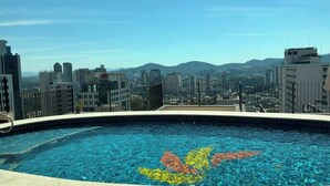 A rooftop swimming pool with a cityscape view.