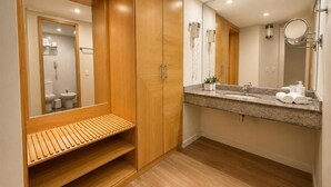 A modern bathroom with a wooden vanity, a large mirror, and a shower area.
