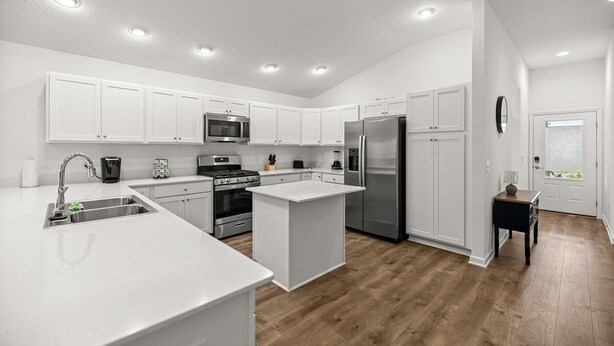 A modern kitchen with white cabinetry, stainless steel appliances, and a central island. - Cozy 2BR Near Eastport Sq. & Middleton | Patio (Sumterville)