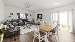 A modern living room with a sofa, coffee table, and dining table. - Cozy 2BR Near Eastport Sq. & Middleton | Patio (Sumterville)