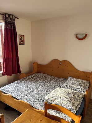 A single bed with a wooden headboard, a patterned bedspread, and a wooden nightstand with a lamp. - 150 m from the lifts - Apartment T2 for 5 people - La Marmotte en Folie (Huez)