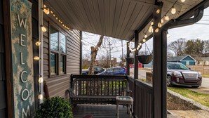 A porch with a bench and a welcome sign, a basket, and string lights. - Private Updated Home W/ Dedicated Work Space - Close to Downtown (Chattanooga)