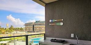 Un balcon donnant sur une piscine, un bùtiment en arriÚre-plan et deux raquettes fixées au mur.