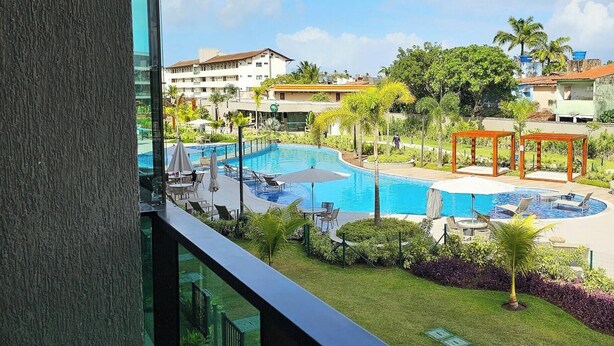 A pool area with multiple swimming pools, lounge chairs, and a gazebo.