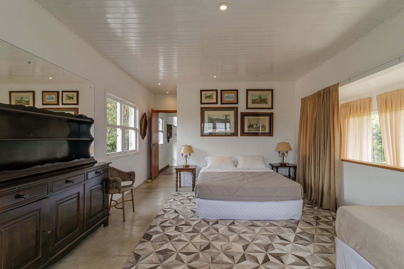 Un dormitorio con cama, cómoda, silla y piano.