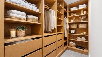 Un vestidor de madera con repisas para toallas dobladas, un perchero para ropa y cajones de guardado.