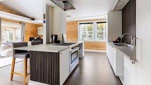 Una cucina moderna con isola centrale, forno a incasso e un'ampia finestra che offre luce naturale.