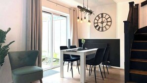 Un'elegante sala da pranzo con tavolo, sedie e un orologio a parete.