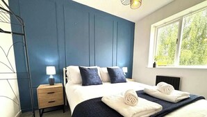 Una camera d'albergo con un letto, comodini e una finestra che si affaccia sul verde.