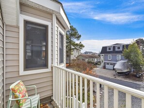 A residential property with a covered outdoor area, a visible garage, and a neighboring house. - Coastal House Near the Beach | Kitchen, Deck & BBQ (Bethany Beach)