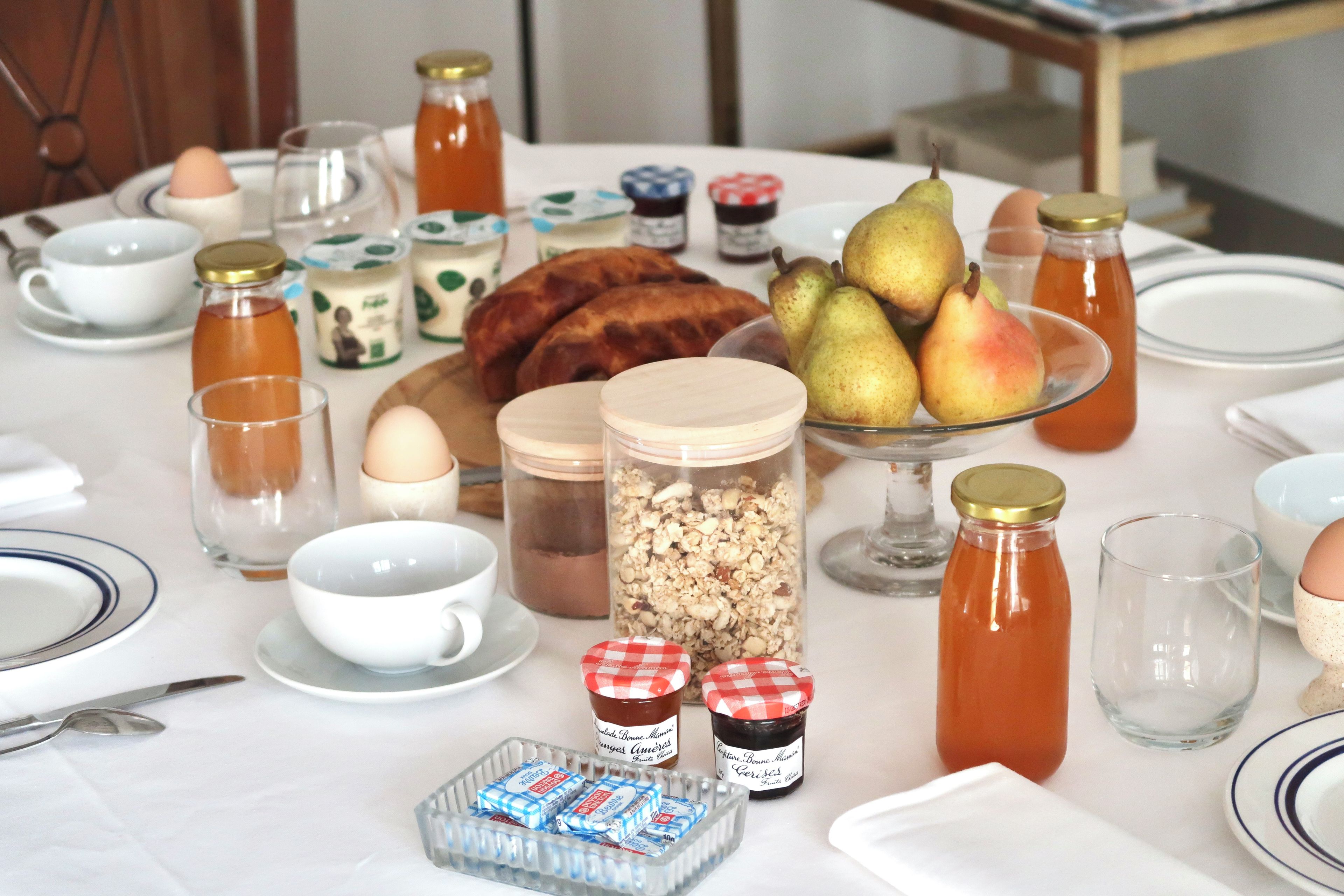 Ett frukostbord dukat med olika sorters mat, inklusive bröd, frukt och tillbehör.