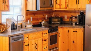 A kitchen with wooden cabinets, a microwave, a stove, and a dishwasher.