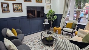 A living room with a TV, framed artwork, a potted plant, and seating. - 10% Off Weekly Stay|Chatsworth Retreat|Sleeps 7 (North Yorkshire)