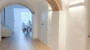 A spacious hallway with wooden flooring, white walls, and exposed brick arches. - House in Belalcazar overlooking the Castle (Belalcázar)