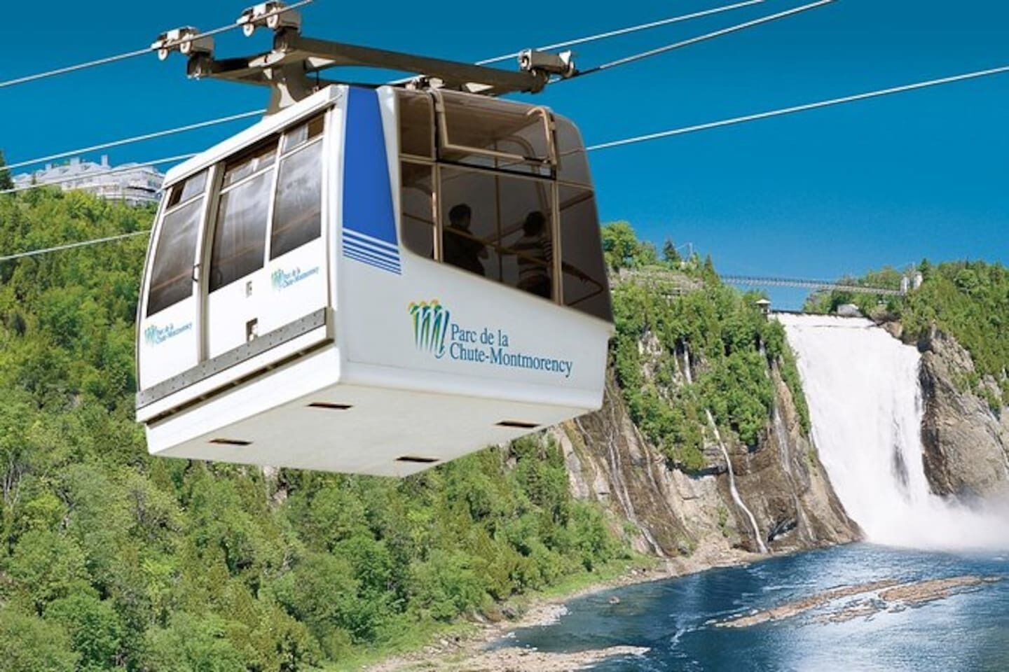Teleférico com a inscrição "Parc de la Chute-Montmorency" e uma cachoeira ao fundo.