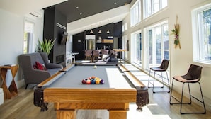 A modern living room with a pool table, seating area, and large windows. - 2CH: Relaxation + Spa + Sauna + BBQ + Wi-Fi (Pont-Rouge)