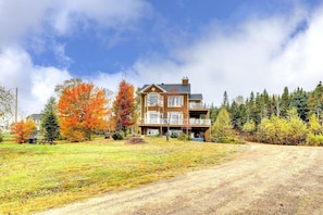 A two-story house with a front porch and a covered outdoor area.