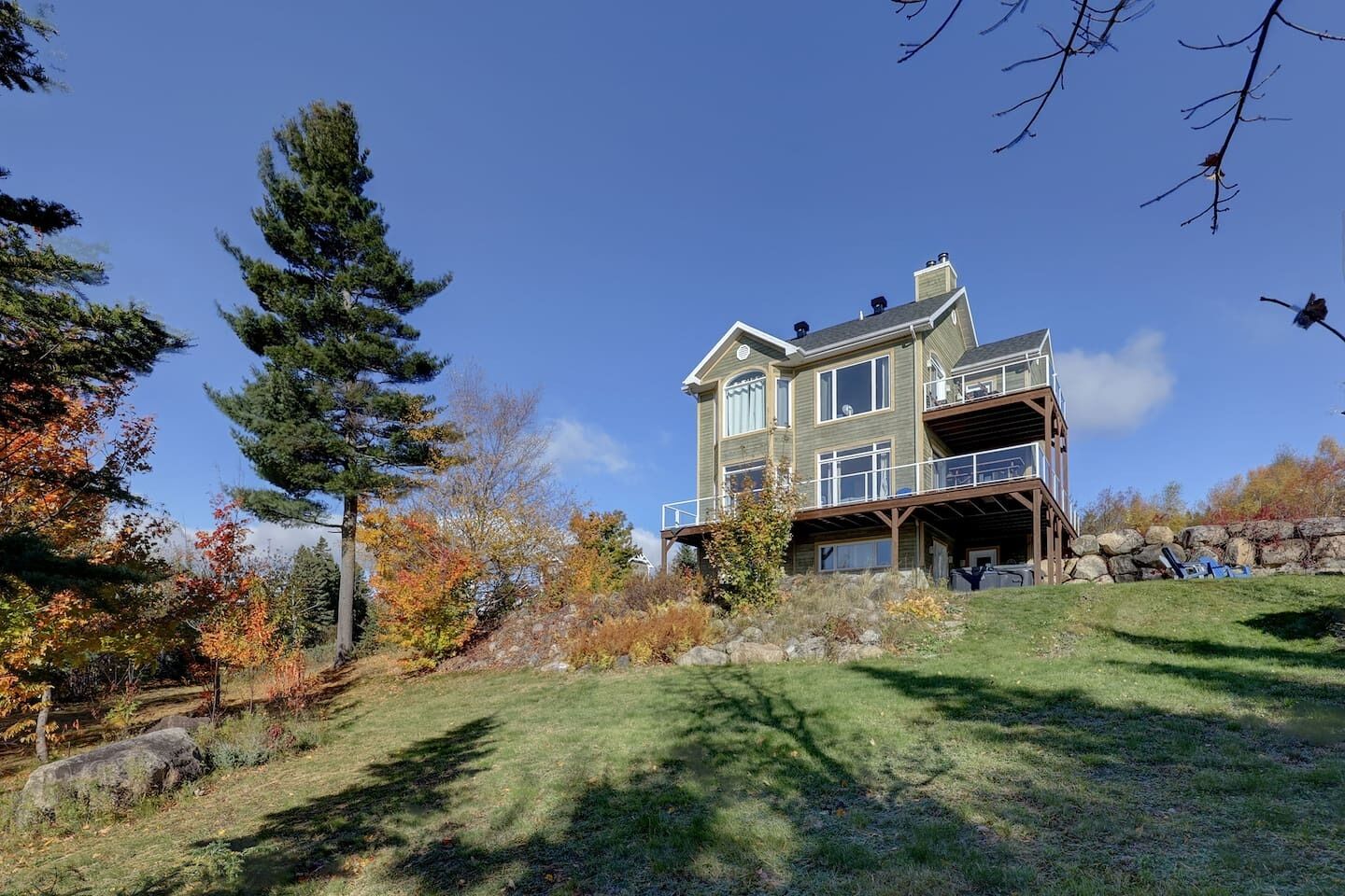 A large, multi-story house with a balcony and a covered porch area.