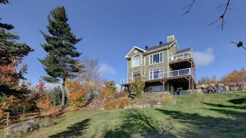 A large, multi-story house with a balcony and a covered porch area.