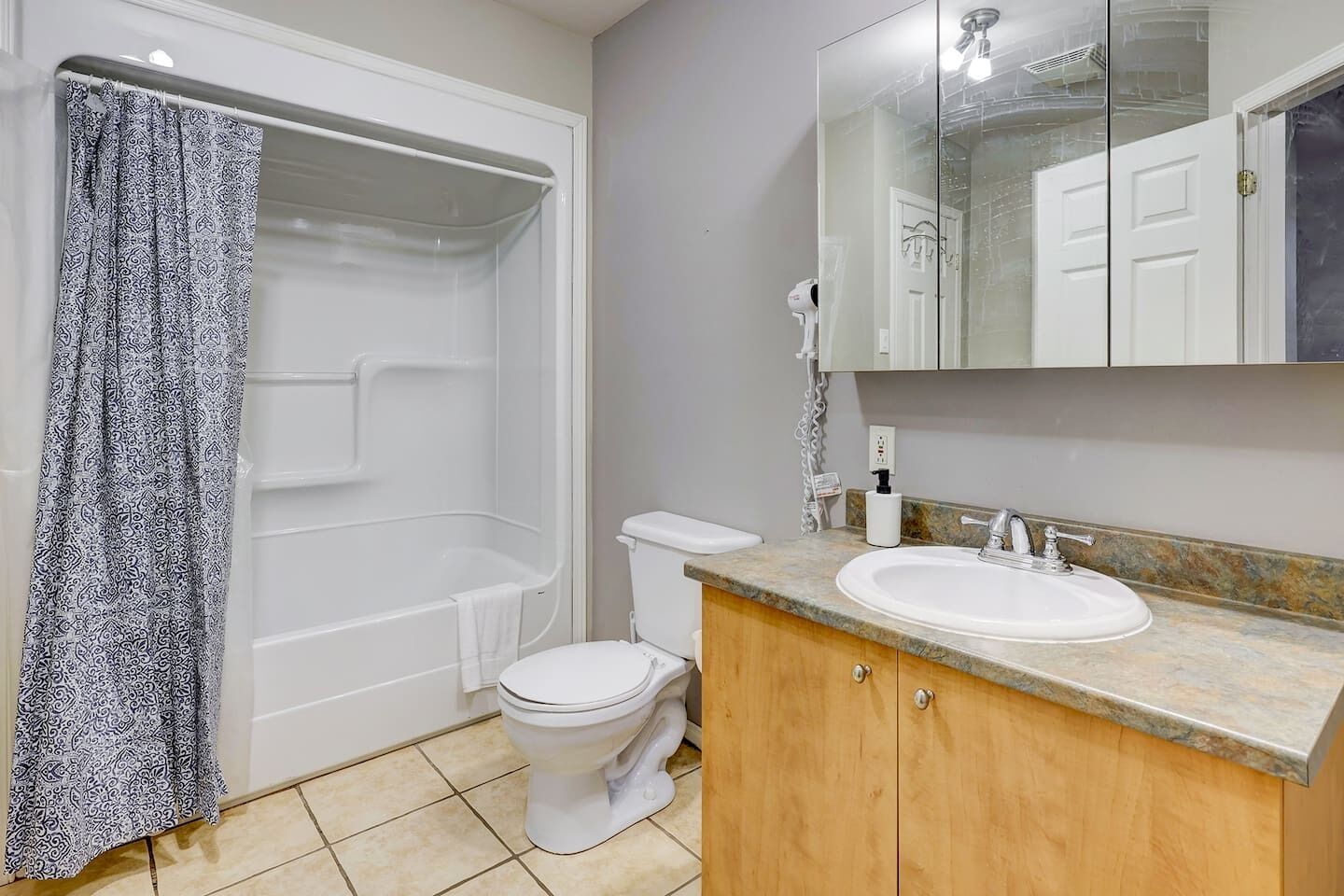 A bathroom with a shower, toilet, and sink.
