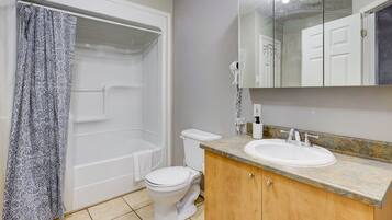 A bathroom with a shower, toilet, and sink.