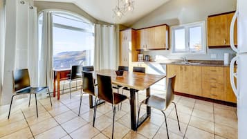 Una cocina moderna con armarios de madera y un comedor con una mesa grande y sillas.