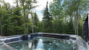 Un jacuzzi en un área boscosa, rodeado de árboles.