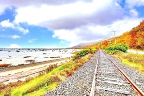 A railway track leading towards a body of water with autumn foliage on the sides. - L’Estran - 5BR/3BA + Spa + View + FP - Lower Unit (Petite-Rivière-Saint-François)