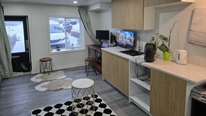 Una cucina moderna con un'ampia finestra, un computer e una macchina per il caffè.