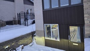 Una moderna casa a due piani con un'ampia finestra e un portone.