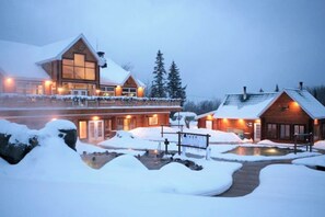 A lodge with a large wooden building, a smaller cabin, and a snow-covered deck. - Oasis Du Massif - Spa, BBQ, fireplace and nature (Saint-Paul-de-Montminy)