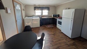 Una cocina compacta equipada con lavadora, microondas, estufa y refrigerador.