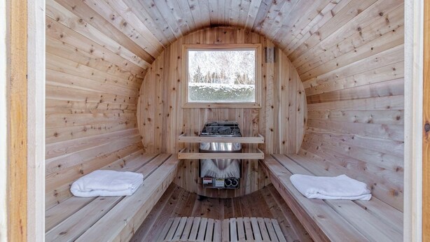 Una sauna con paredes de madera, un banco, una ventana y un generador de vapor.