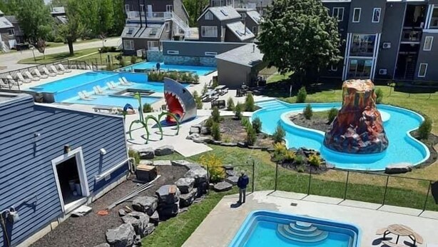 A residential area with a large swimming pool, a slide, and a water feature.