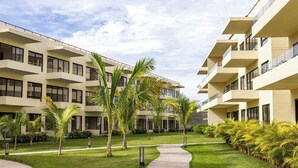A modern multi-story building with balconies and large windows. - Garden-view patio retreat w/ pool & BBQ (Tondoroque)