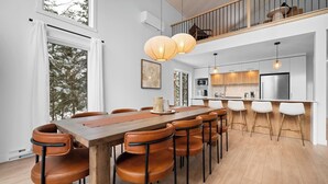 Cocina moderna con una isla central, muebles blancos y electrodomésticos de acero inoxidable.