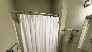 Een kleine badkamer met toilet, wastafel en douchegordijn.