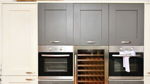 Une cuisine équipée de deux fours, d’un réfrigérateur à vin et d’un meuble à vin intégré.