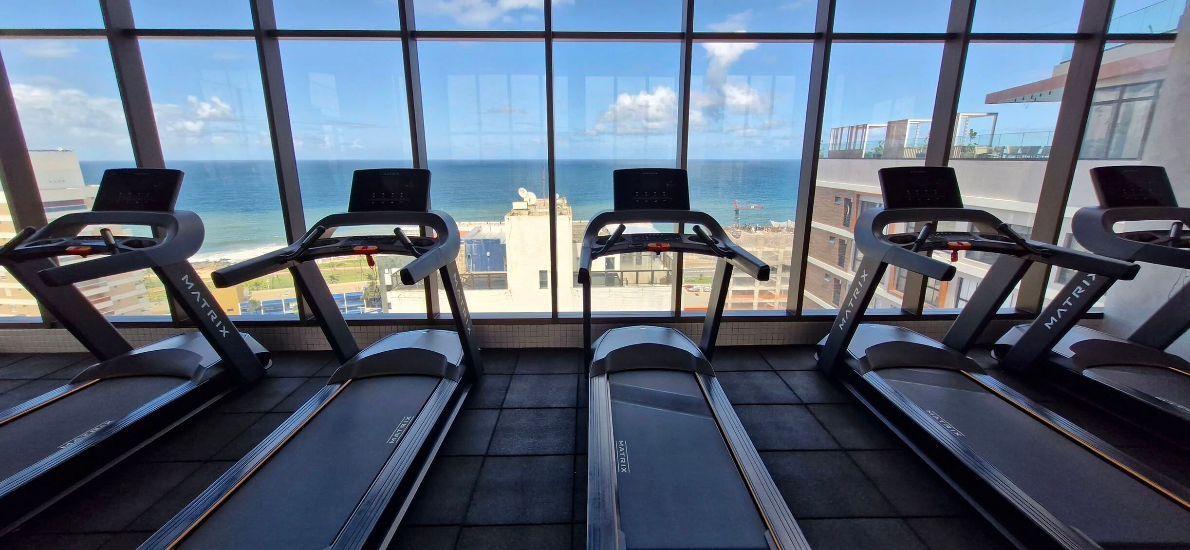 Una palestra con tapis roulant e vista sull'oceano.