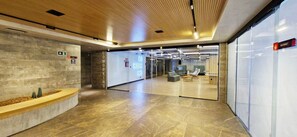 A modern lobby with a reception desk, a glass partition, and a sign for Coworking. - COARM0111 - Condominio LIT 760 (Salvador)