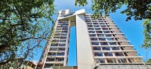Een hoog gebouw met meerdere verdiepingen, grote ramen en balkons.