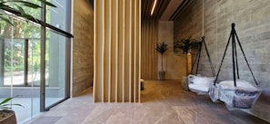 Ein modernes Interieur mit einer Glastür, die nach draußen führt, einer Wand aus Holzleisten und hängenden Taschen.